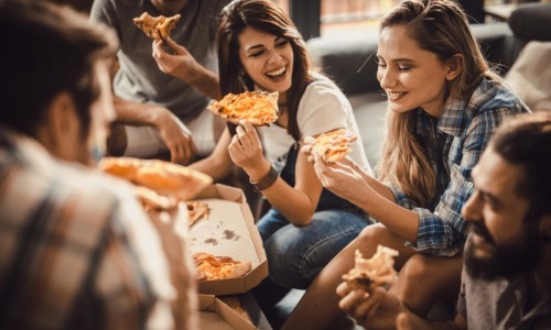 a group of people eating pizza